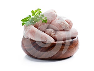 Small chicken sausages in wooden bowl isolated on white