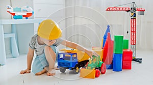 Small child 4 years old, playing with a large number of colorful plastic toys in the room, construction of various