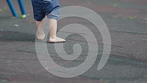 small child bare feet walking playground summer outdoors baby blue shorts dirty