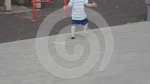 small child bare feet walking playground summer outdoors baby blue shorts dirty