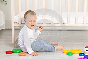 A small child does not want to study, a frustrated baby boy 2 years old sitting with toys, early development