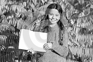 Small child enjoy reading autumn foliage background. Little child enjoy learning in autumn park. Kid study with book