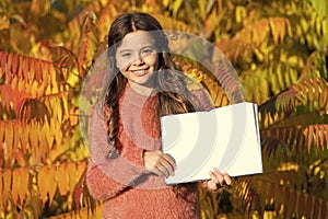 Small child enjoy reading autumn foliage background. Little child enjoy learning in autumn park. Kid study with book