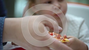 A small child in a fast food cafe eats pizza. Cute little kid girls portrait funny eating in fast food court in a mall