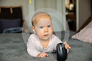 Small child, first steps on the internet, a newborn baby is holding a mouse from the computer