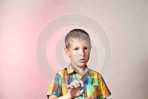 A small child on a gradient colored background in a multi-colored shirt