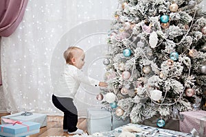 Small child hangs Christmas balls on the tree