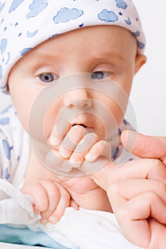Small child holding mother's finger