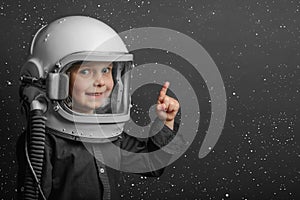 small child imagines himself to be an astronaut in an astronaut`s helmet