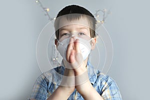 Small child, kid 7-8 years old in a white mask class FFP2, close-up face, medical concept, tired of quarantine, concept of COVID-