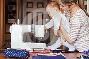 Small child learns new knowledge, along with his mother inspects sewing machine. Work at home, parenting, parents and