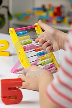 A small child learns to count on abacus, mathematics, arithmetic for children.