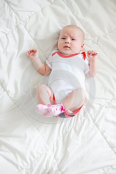 A small child lies pushing legs to his tummy. Colic or stomach cramps in children under 3 months. Diseases of infants.