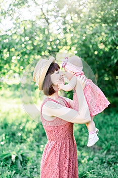 A small child, a little girl sitting in lap of her mother, looking into each other`s eyes, hugs her, warm and Sunny day