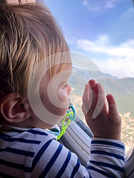 A small child looks into the window of an airplane. Tourism concept