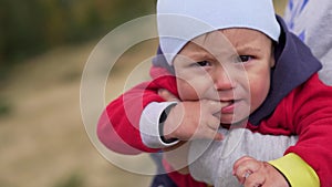 Small child in a mother`s hands. First teeth grow