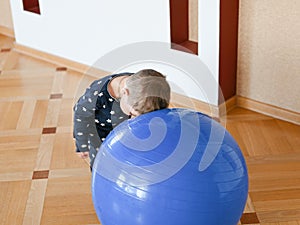 A small child is playing with a ball. Baby banging his head on a ball