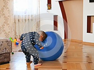 A small child is playing with a ball. Baby banging his head on a ball