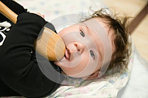 A small child is playing with a spoon. old kitchen toys. close up of babies hands playing with wooden spoon and pot baby chef