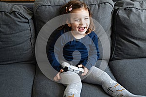 Small child playing video games with gamepad on console. Modern kids dependancy of virtual reality.