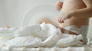 A small child plays with baby diapers, background, hygienics