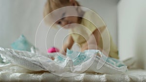 A small child plays with baby diapers, background, hygienics