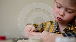 A small child plays in the sandbox at home. Boy makes sand molds