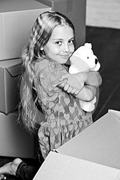 Small child prepare toys for relocation. Kid girl relocating boxes background. Relocating concept. Delivery service