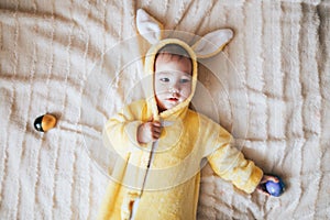 A small child with a rabbit costume. Lying on bad