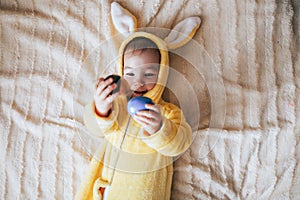 A small child with a rabbit costume. Lying on bad