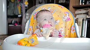 Small child sitting on the highchair and fidgets.