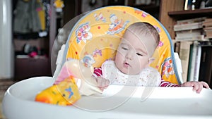 Small child sitting on the highchair and fidgets.