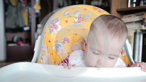 Small child sitting on the highchair and fidgets.