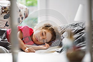 A small child sleeps sweetly in his bed. Healthy sleep of the girl, ventilation. Morning, wake up, sunlight from the window. Early