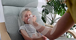 Small child spraying a tube of medicine into nose