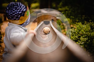 Small Child standing at a big wooden ball path in the Zillertal, Austria in the alps