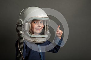 a Small child wants to fly an airplane wearing an airplane helmet