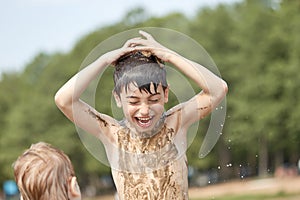 Small children bathe in water smear dirt on their body and rejoice