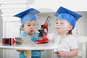 Small children in blue graduation hat adjust photo