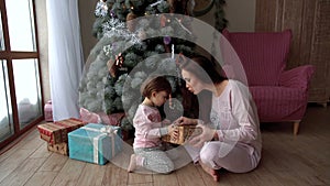 Small children enjoy gifts in the Christmas tree