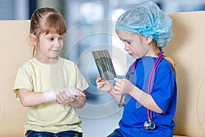 Small children playing a traumatologist and a patient with fracture photo