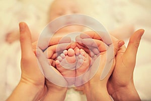 Small children's feet in the hands of parents
