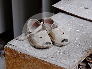 Small children`s sandals in an abandoned kindergarten in Pripyat. Old children`s shoes