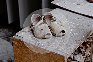 Small children`s sandals in an abandoned kindergarten in Pripyat. Old children`s shoes