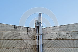 small chimneys (smokestack) pipe on yellow wall with blue sky