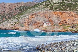 Small Christian church on a rocky shore near the sea