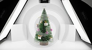 Small Christmas tree with ornaments in a studio setup with softboxes