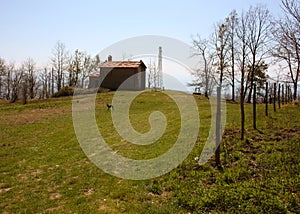 Small church abandoned, in disuse, on the Apuan Alps of the Tuscan Apennines in a clearing on a sunny spring day