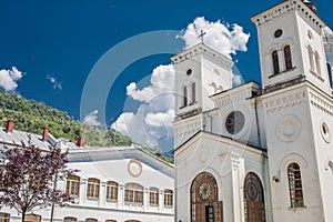 Small church, pleasant countryside view against blue sky. Country road and idyllic pastoral village landscape near Valcea county