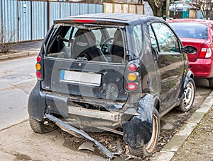 Small city car involved in an accident. Crashed and damaged car on the side of the road